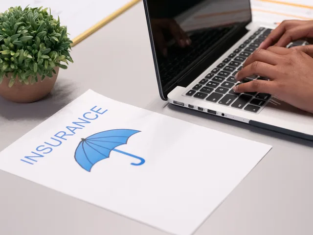 Close-up of hands typing on laptop with an insurance document visible on the desk. Business insurance key metrics in England: 12% IPT, eight-week complaint clock and Cyber Essentials figures
