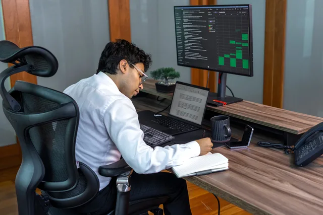A focused professional analyzing data on computer in a modern office setting. A business insurance strategy for English small businesses